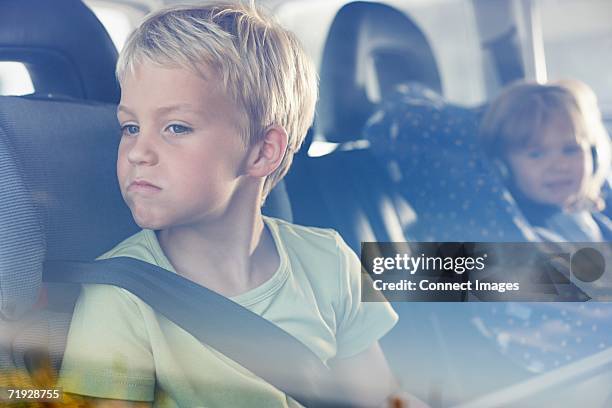 two children sat in the back of car - toddler in car foto e immagini stock