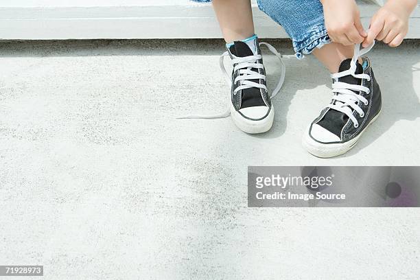 kind seine schnürsenkel binden - boy tying shoes stock-fotos und bilder