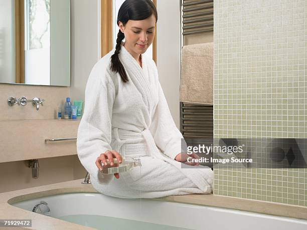 young woman preparing a bath - apothecary bottle stock pictures, royalty-free photos & images