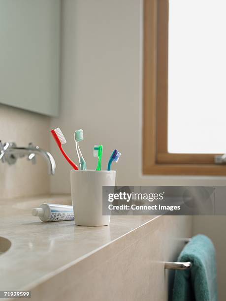 toothbrushes in a cup - toothbrush stock pictures, royalty-free photos & images