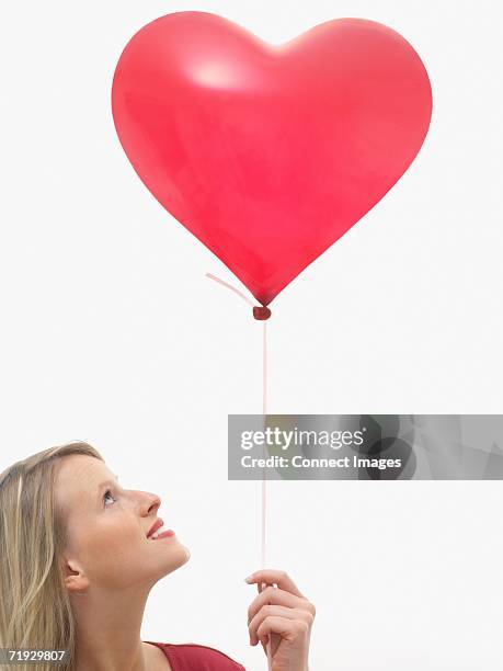 woman holding heart shaped balloon - heart balloon stock pictures, royalty-free photos & images