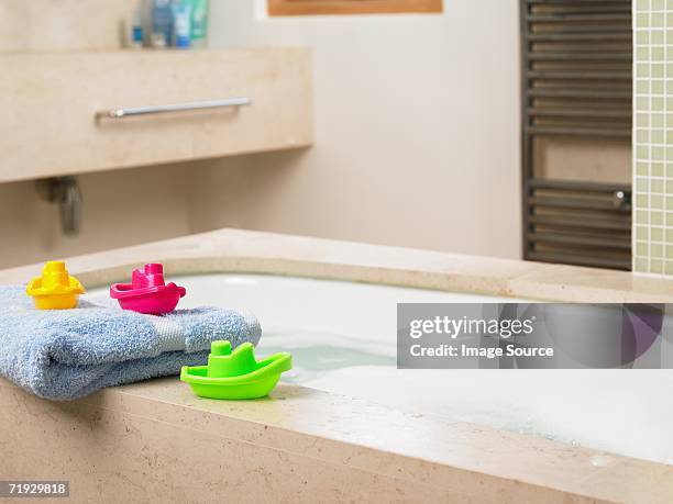 toy boats on edge of bath - boat in bath tub stock pictures, royalty-free photos & images