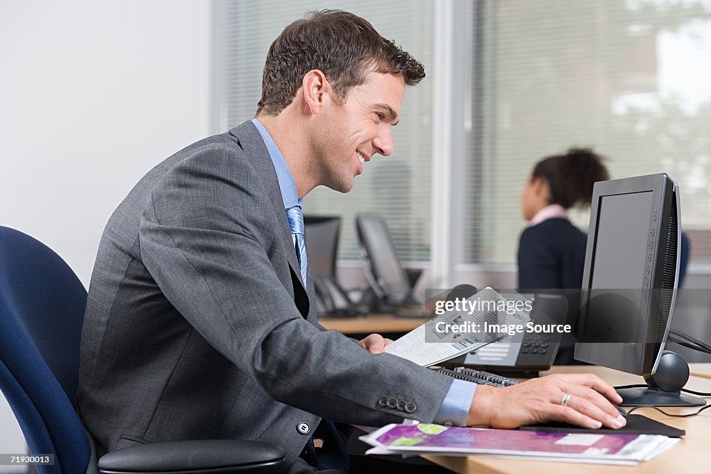 Smiling man at desk with a brochure