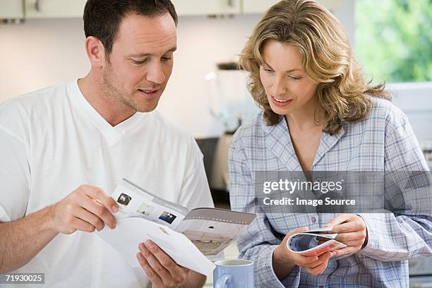 couple looking at brochures - blank magazine ad stockfoto's en -beelden