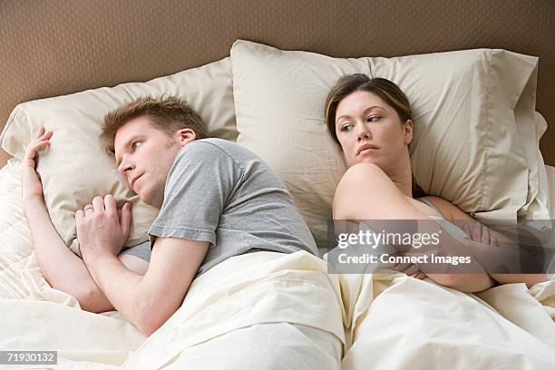 hostile couple in bed - sospetto foto e immagini stock