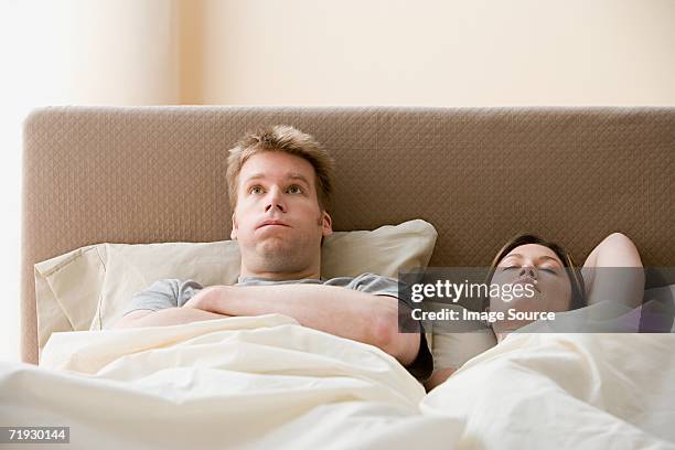 frustrated man and sleeping woman - couple sleeping fotografías e imágenes de stock