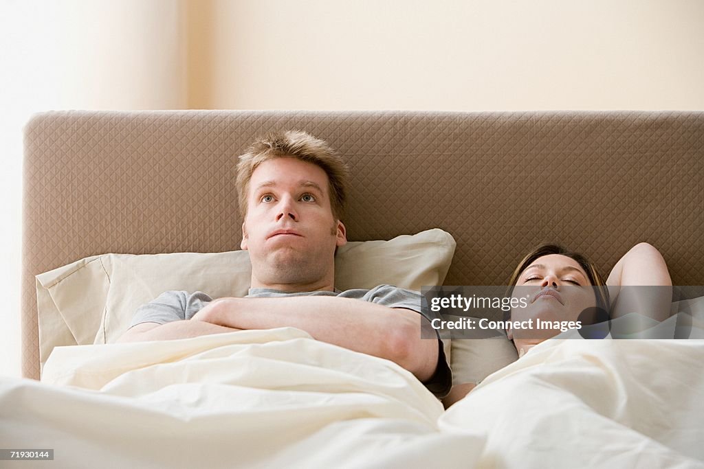 Frustrated man and sleeping woman