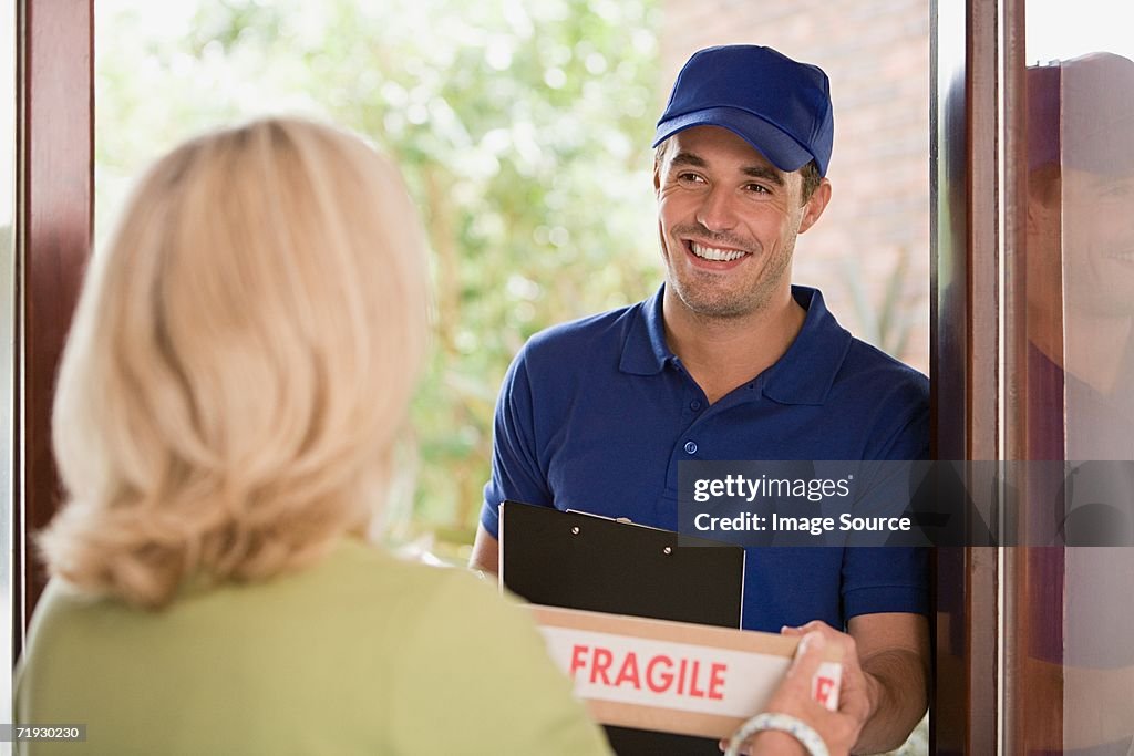 Woman getting a parcel from delivery man