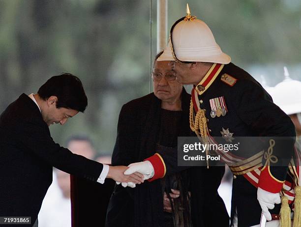 King George Tupou V , shakes hands with the Prince Naruhito, Crown Prince of Japan as Queen Halaevalu Mata'aho looks on after the state funeral for...