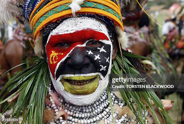 Goroka, PAPUA NEW GUINEA: A Sogomie dancer sports the national flag as part of their face paint during the 50th Goroka singsing in what is believed...