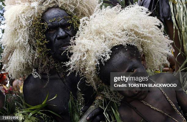 Goroka, PAPUA NEW GUINEA: A Fire Starter boy waits with his father before performing in the 50th Goroka singsing in what is believed to be the...