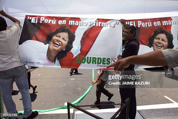 Picture taken 02 March, 2006 in Lima of workers hanging electoral banners before a rally of Peruvian presidential candidate Lourdes Flores, of the...