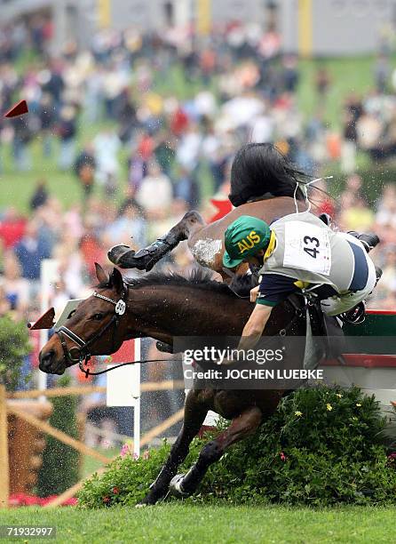 Australian rider Shane Rose on "All Luck" falls as he takes part in the Eventing Cross Country competition of the World Equestrian Games in Aachen 26...