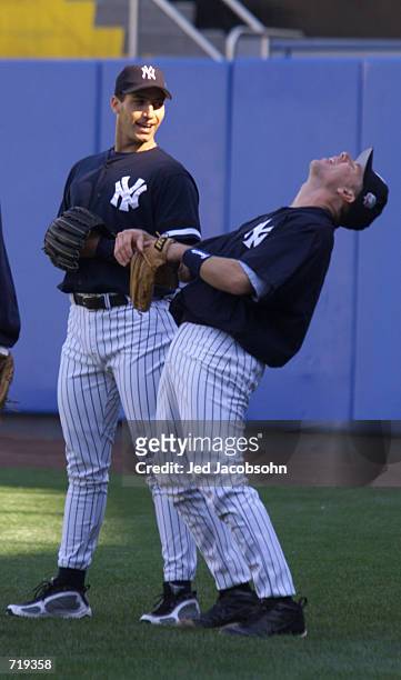 Starting pitcher Andy Pettitte of the New York Yankees laughs with teammate Scott Brosius the day before game 1 of the World Series against the New...