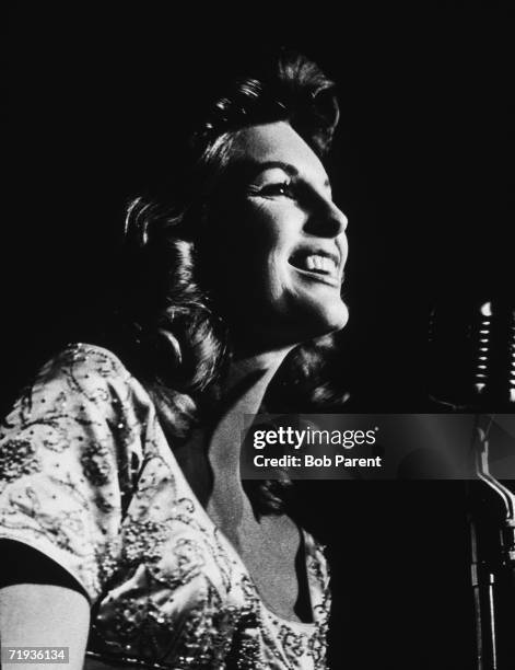 American actor and singer Julie London , singing at a microphone, circa 1955.