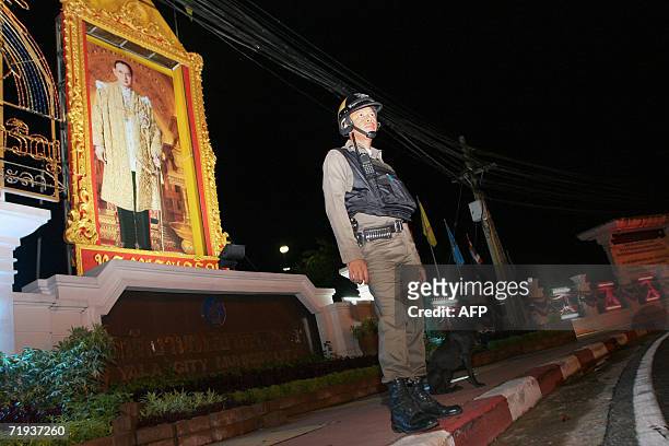 Thai soldier stands guard in front of a big portrait of Thai King Bhumibol Adulyadej at a government building in Thailand's restive southern Yala...