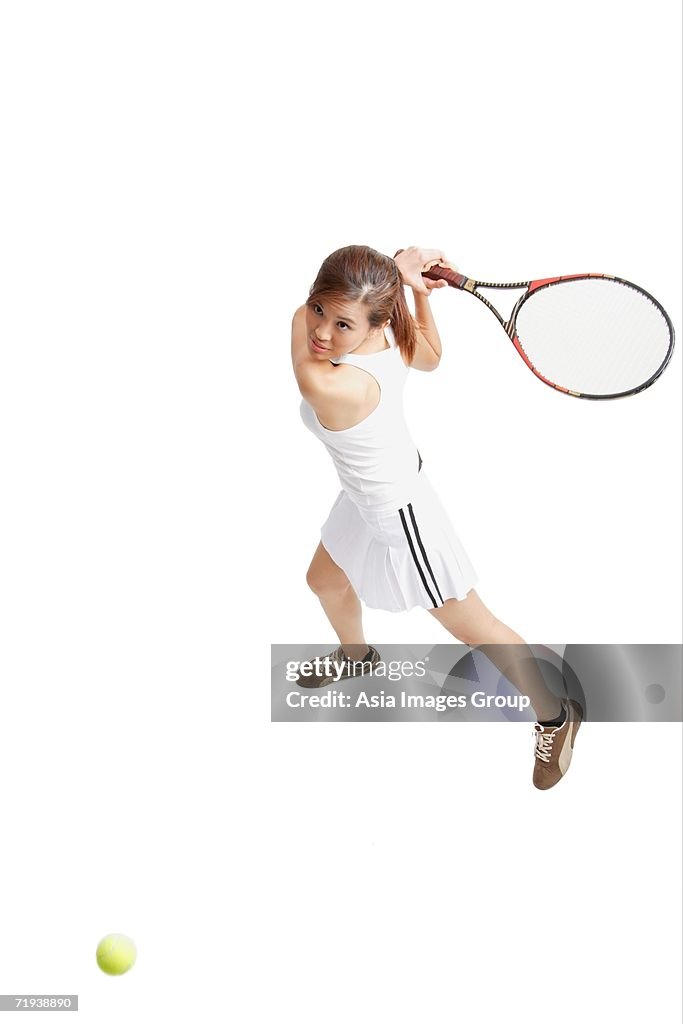 Young woman holding tennis racket, waiting for ball