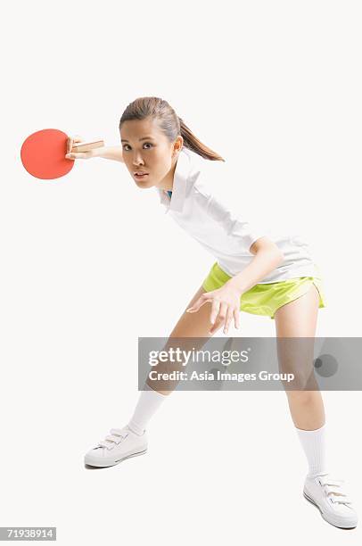 young woman playing table tennis, studio shot - women's table tennis stockfoto's en -beelden