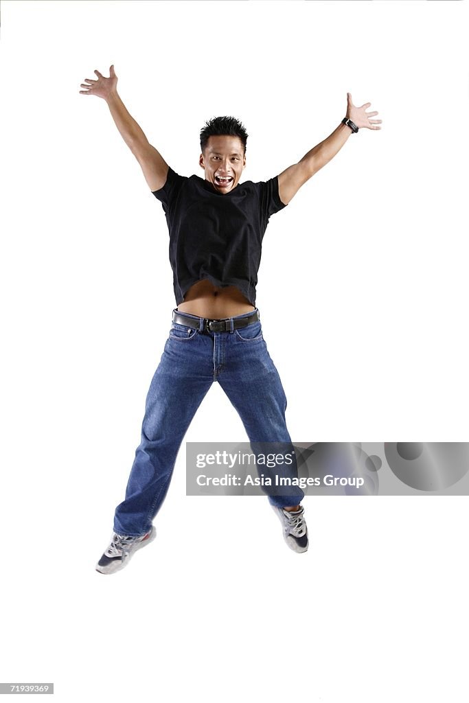 Young man jumping, arms and legs outstretched