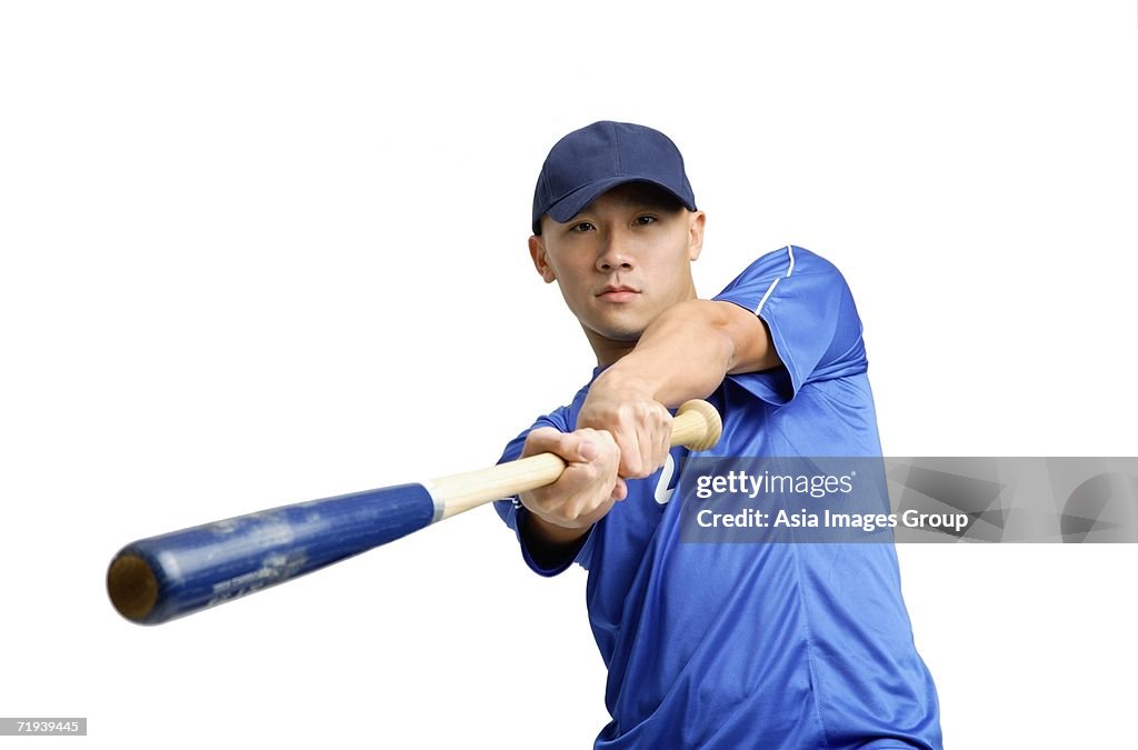 Young man swinging baseball hat