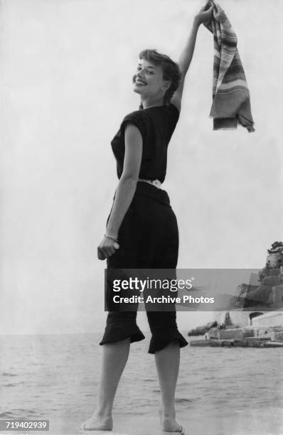 Belgian-born actress Audrey Hepburn in a black beach outfit, circa 1955.