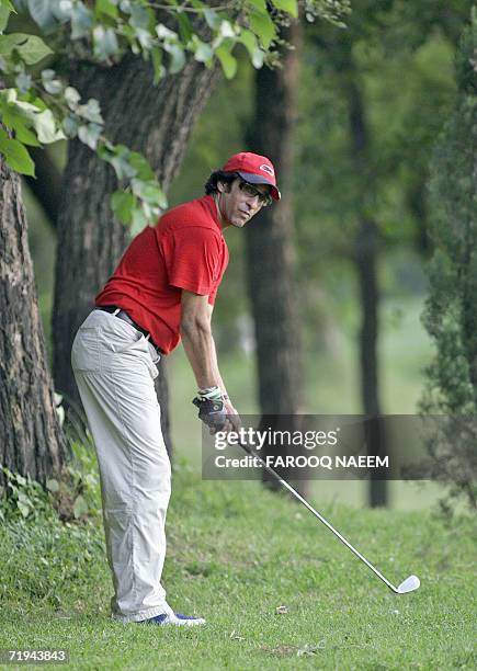 In this picture taken 19 September 2006, former Pakistani cricketer Wasim Akram watches his ball during a golf game in Islamabad. Akram said...