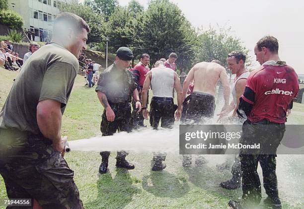 The England rugby team get a hosing down after training with the Royal Marines at Lympstone, Devon, 28th July 1999.