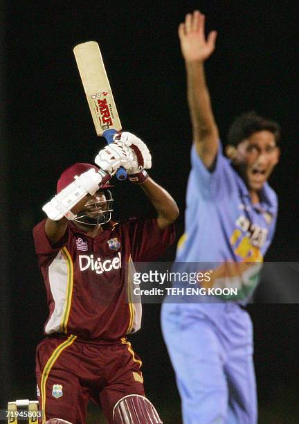 Kuala Lumpur, MALAYSIA: West Indian captain Brian Lara raises his bat while Indian pacer Ajit Agarkar raises his hands during a one-day match of the...