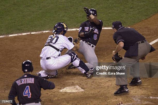 Timo Perez of the New York Mets is tagged out at home by catcher Jorge Posada of the New York Yankees in the fifth inning during game one of the...