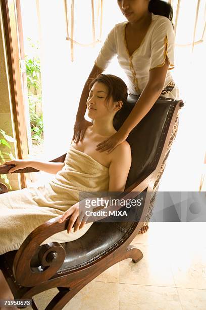 young woman having shoulder massage - bali massage stock-fotos und bilder