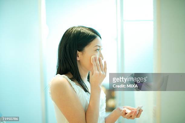young woman applying make-up - powder puff stock pictures, royalty-free photos & images