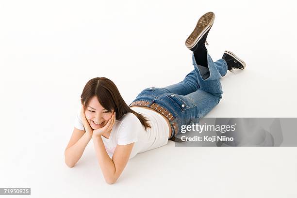 young woman lying on front smiling - allongé sur le devant photos et images de collection