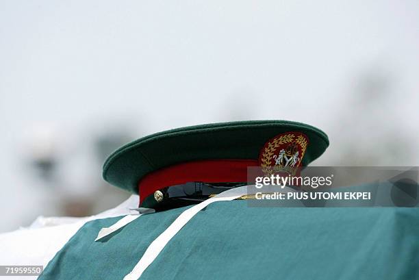 The cap of a Nigerian Army General, who died in a plane crash, is kept on the casket carried by pall bearers 21 September 2006 for the burial at the...