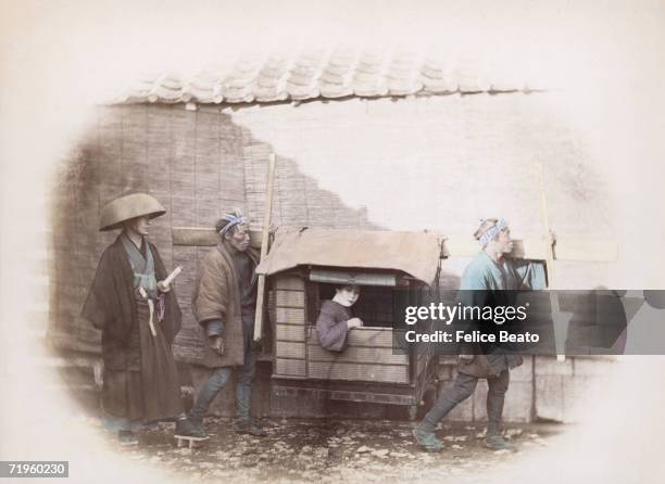 Two Japanese kago bearers carrying a woman in a sedan chair, circa 1865. A samurai with two swords accompanies the group.