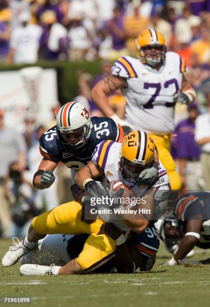 Running back Jacob Hester of the LSU Tigers gets tackled by the face mask by linebacker Will Herring of the Auburn Tigers during a game on September...