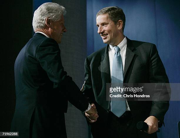Klaus Kleinfeld, President and CEO of Siemens AG , shakes hands with former U.S. President Bill Clinton September 21, 2006 at the Clinton Global...