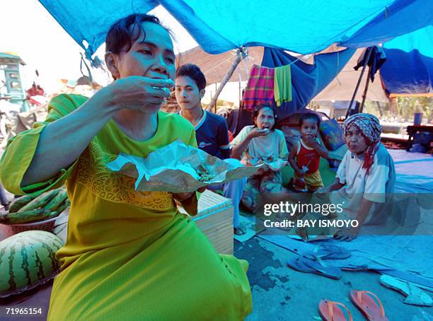 Villagers enjoy their lunch at a temporary shelter on the toll road as a gushing out mud of a Lapindo Brantas Inc. Gas exploration well in Sidoarjo,...