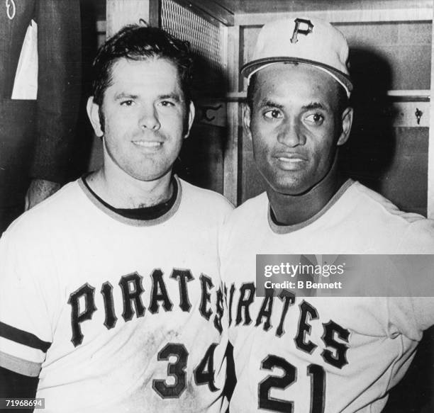 Baseball players and teammates Nelson Briles and Roberto Clemente of the Pittsburgh Pirates pose together in the locker room of Three Rivers Stadium...