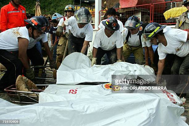 Socorristas trabajan en el rescate de los cuerpos de cinco hombres y una mujer que murieron soterradas en el km 25 de la carretera a El Salvador, a...