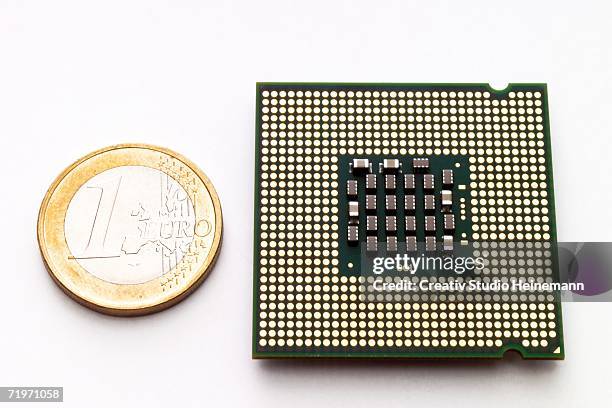 processor chip by euro-coin, elevated view - 1 euro stock-fotos und bilder