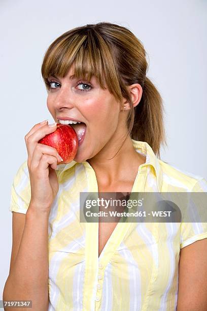 young woman biting apple, portrait, close-up - adult female eating an apple stock pictures, royalty-free photos & images