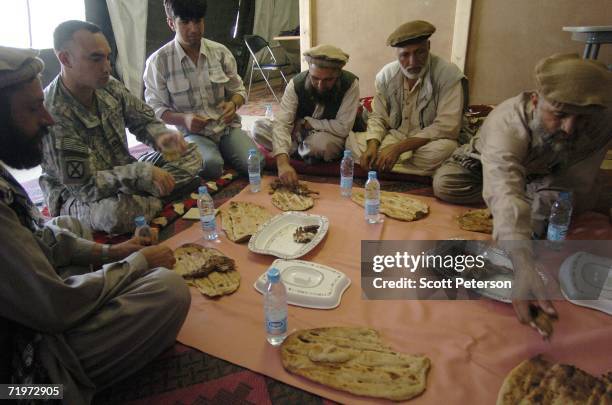 Army Captain Dennis Sugrue, of Watertown, New York, meets with elders from Kamdesh District of Nuristan, to discuss projects in their villages...