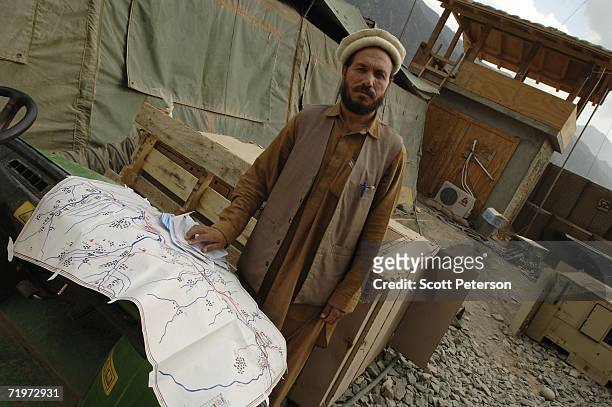 Afghan teacher and Pashto language radio announcer Golamrahim Muridi proudly shows a map illustrating the reach of broadcasts of news and popular...