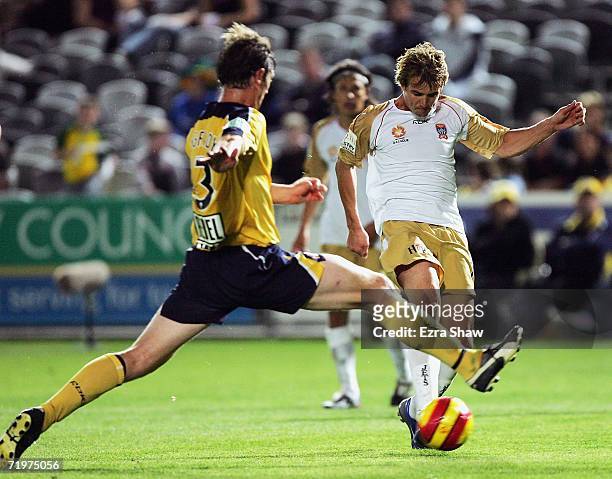 Joel Griffiths of the Newcastle Jets kicks the ball past Paul O'Grady of Central Coast Mariners to score a goal during the round five A-League match...