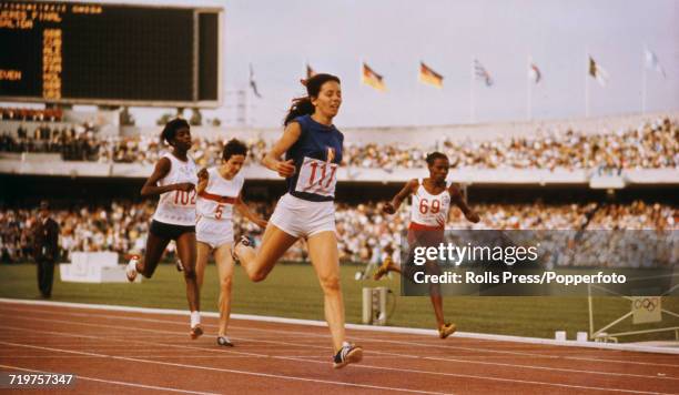 French track and field athlete Colette Besson crosses the finish line in first place to win the gold medal in the final of the Women's 400 metres...