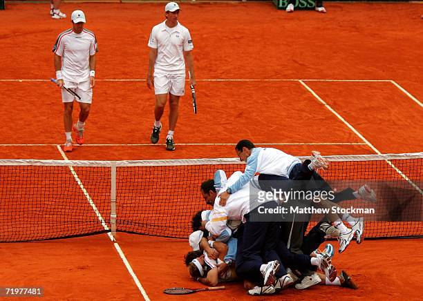 Members of team Argentina pile on David Nalbandian of Argentina after match point against Paul Hanley and Wayne Arthurs of Australia during the World...