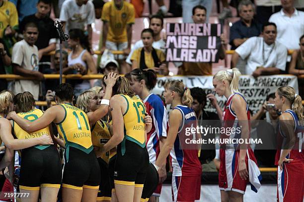 Australia's basketball players celebrate their victory 91-74 as Russia's Natalia Vovopynova , Maria Stepanova and Ilona Korstin pass by them at the...
