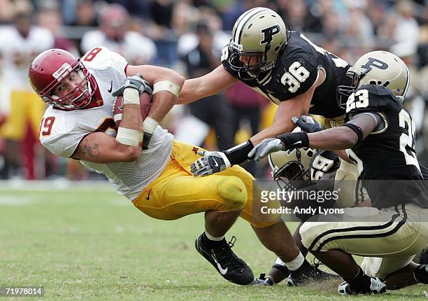 Matt Spaeth of the Minnesota Golden Gophers is tackled by Dan Bick, Standford Keglar and Justin Scott of the Purdue Boilermakers during a Big Ten...