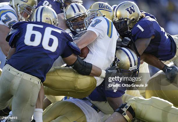 Quarterback Ben Olson of the UCLA Bruins is tackled by Daniel Te'o-Nesheim, Wilson Afoa and C.J. Wallace of the Washington Huskies on September 23,...