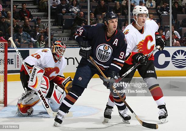 Ryan Smyth of the Edmonton Oilers tries to block goalie Jamie McLennan of the Calgary Flames as Brad Ference of the Flames watches the puck during...